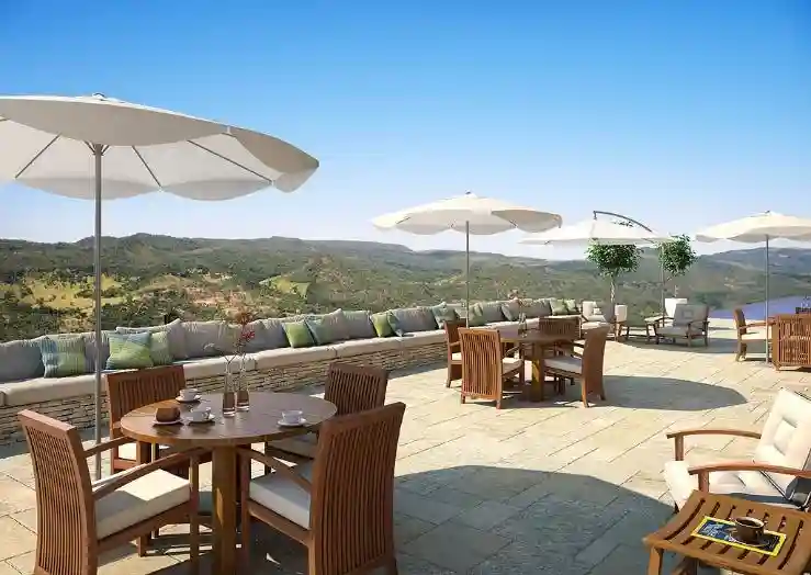 Render de terraço com mesas e guarda-sóis voltado para as montanhas